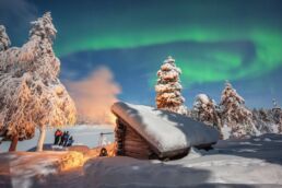 Guests experiencing the Northern Lights in the Arctic wilderness of Finnish Lapland